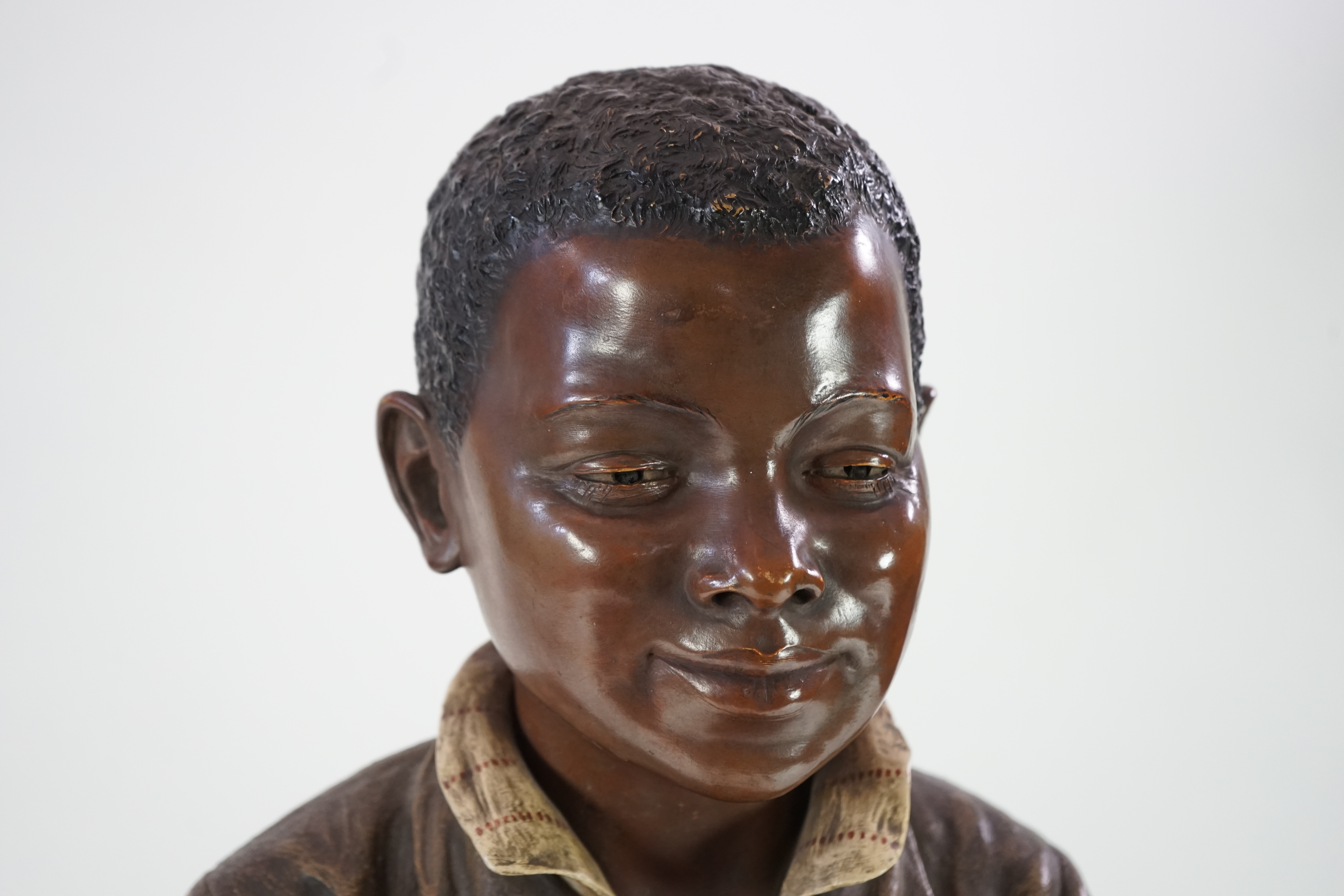 A late 19th century Friedrich Goldscheider life size cold painted terracotta figure of a black boy